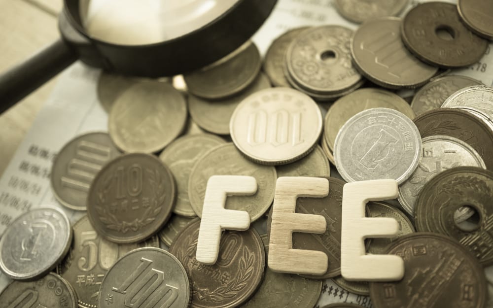 "fee" wooden text and rows of coins for finance and banking concept