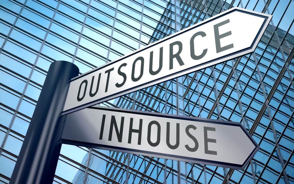 Street signage of Outsourse and Inhouse in different direction, infront a building